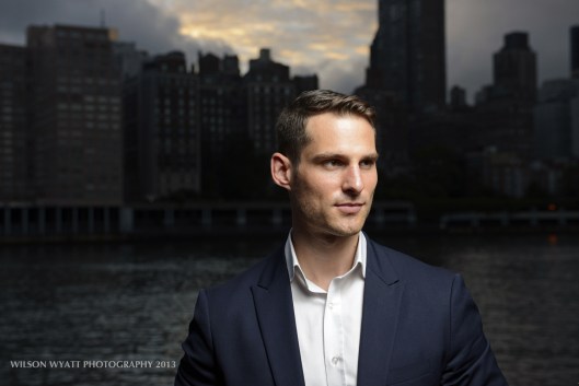 Model Andy Mizerek with background of New York skyline at dusk.